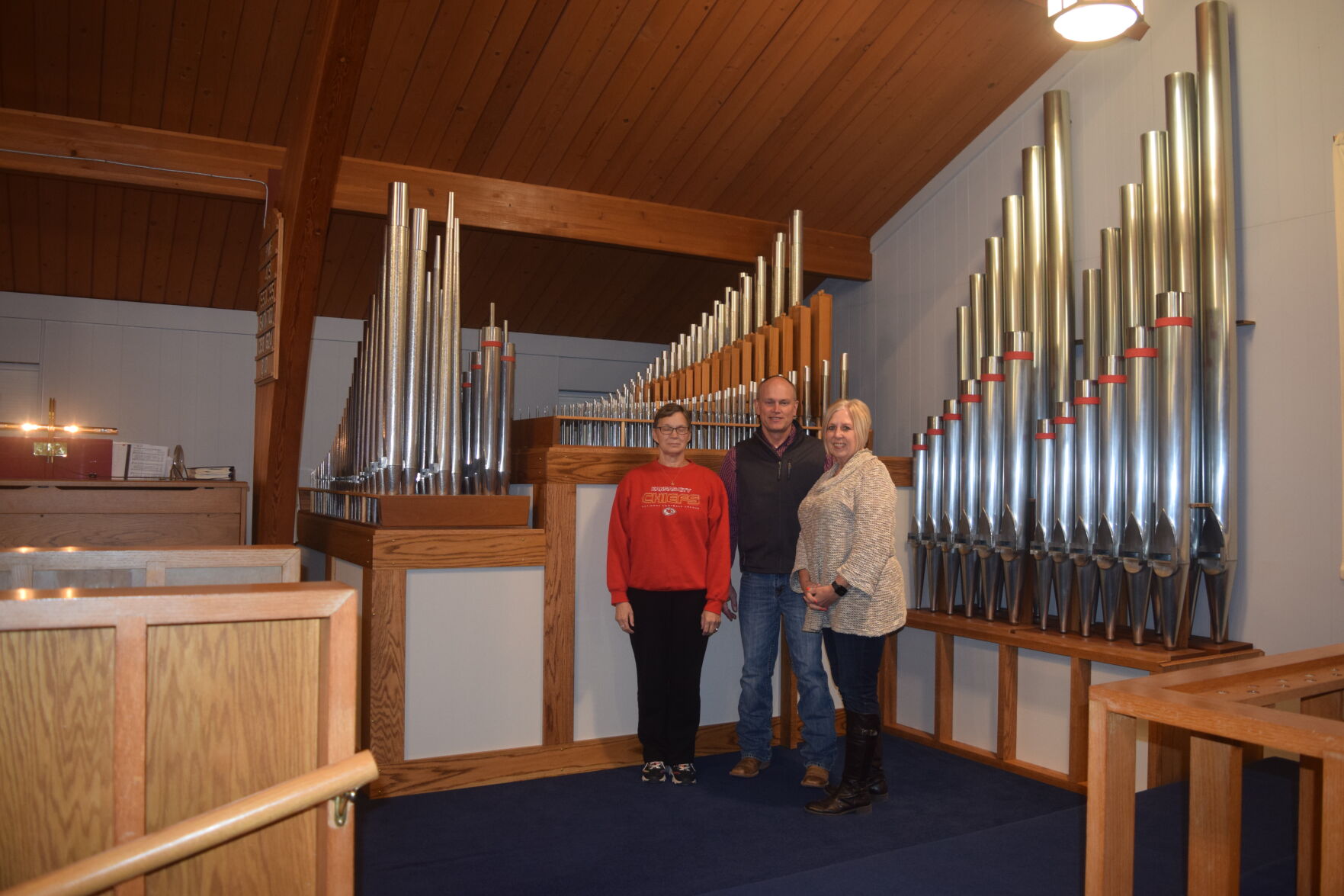 Gilchrist, Rankin and Schwab pose in front of the new Faith Lutheran pipe organ